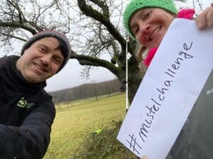 Zwei Personen halten ein Schild hoch mit #mistelchallenge